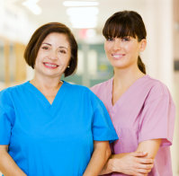 couple of caregivers smiling at the camera
