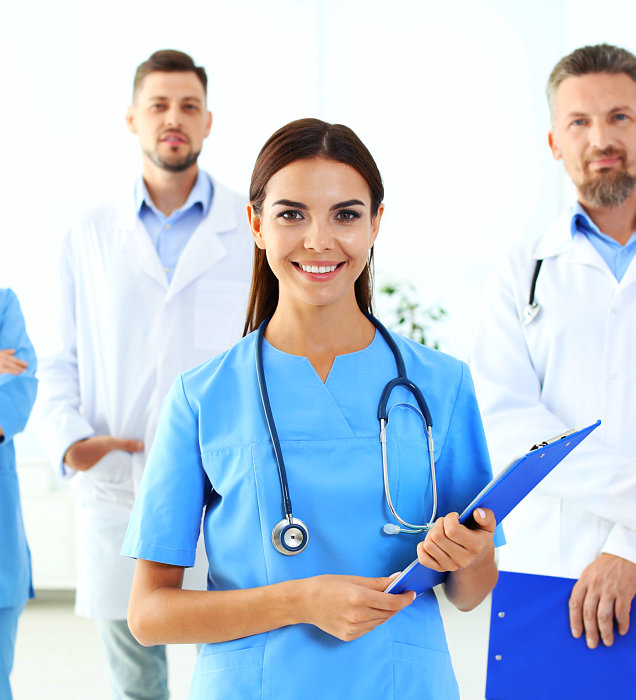 medical personnel holding a file smiling at the camera