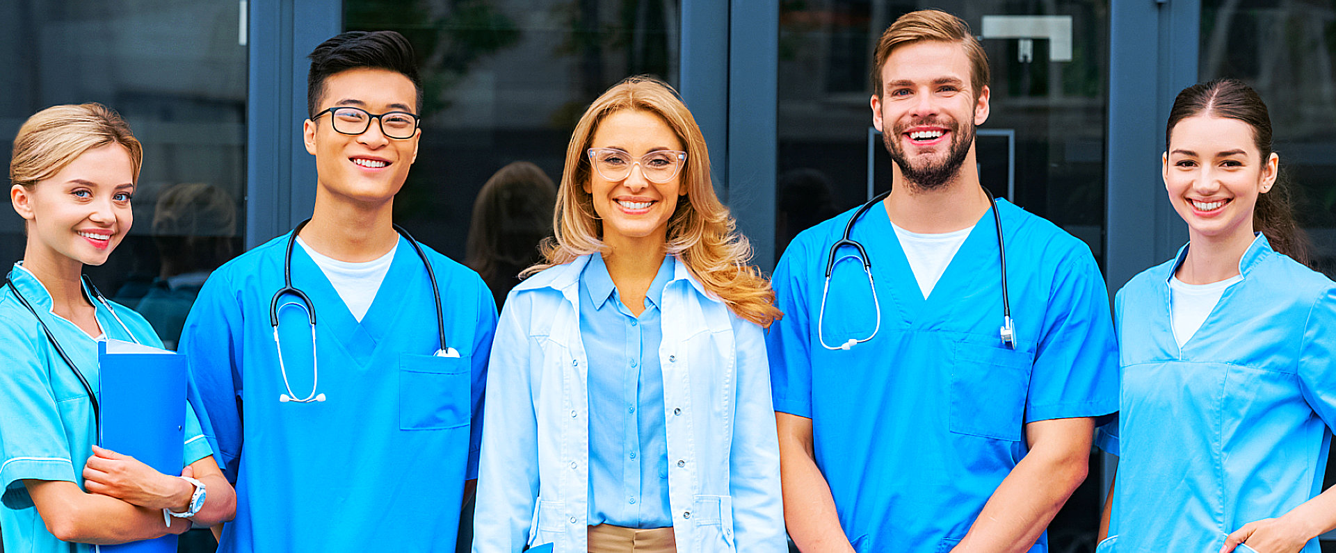 group of medical personnel outside the hospital smiling at the camera
