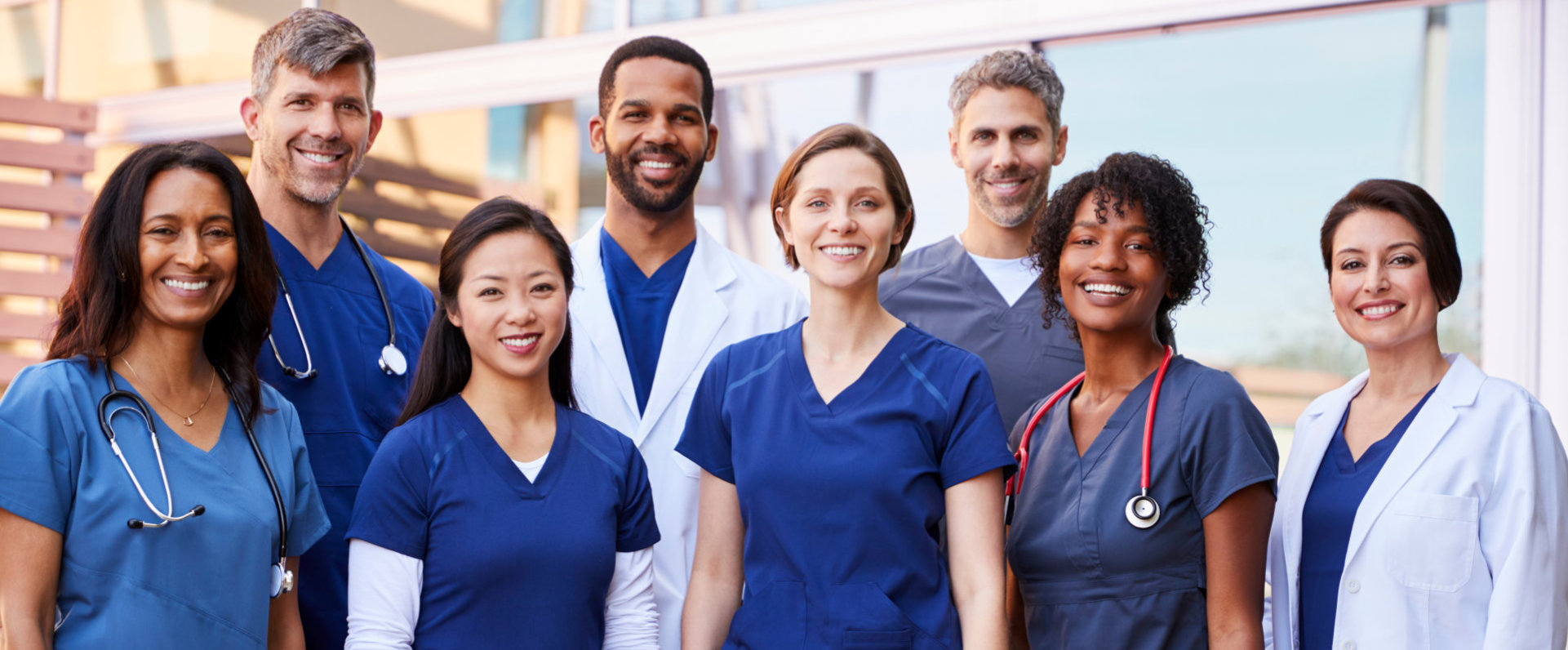 Smiling medical team standing together outside a hospital